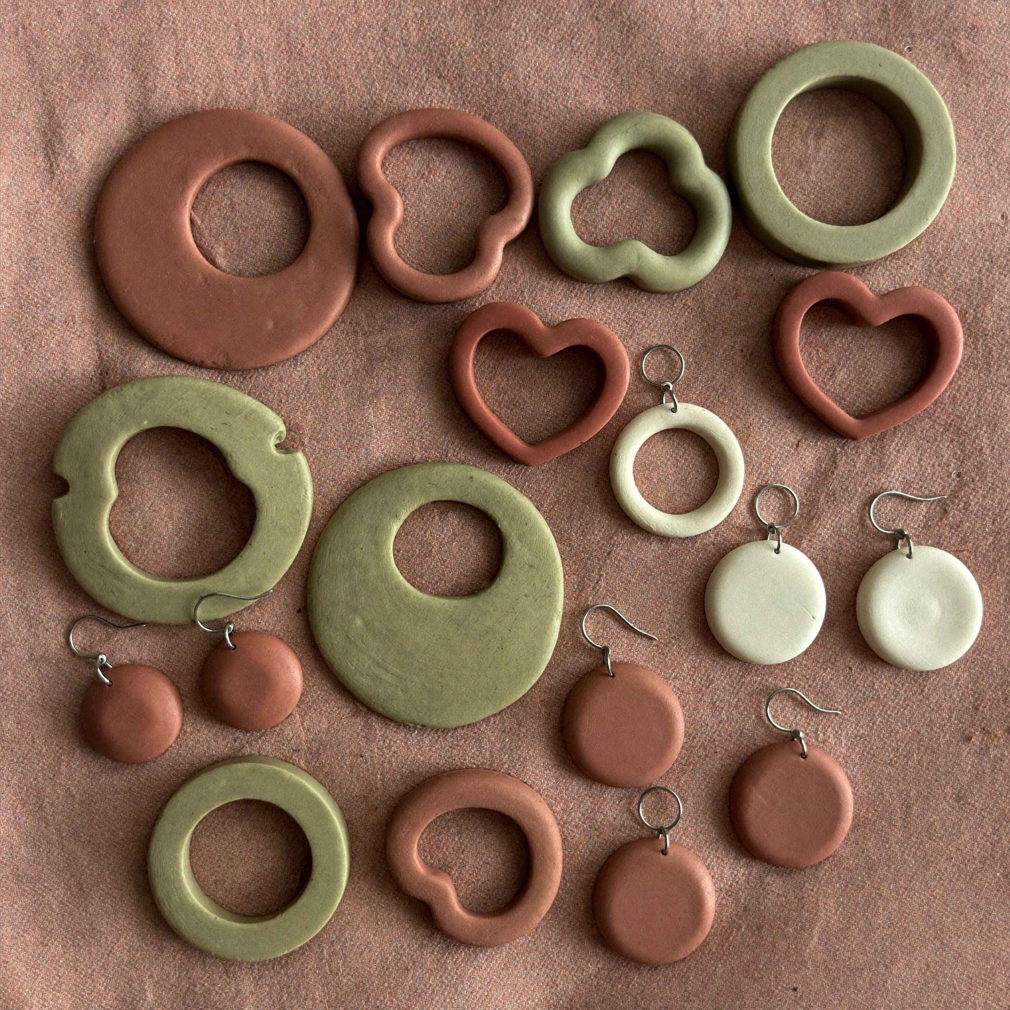 Terracotta and sage clay earring cutters with finished polymer clay earrings on linen