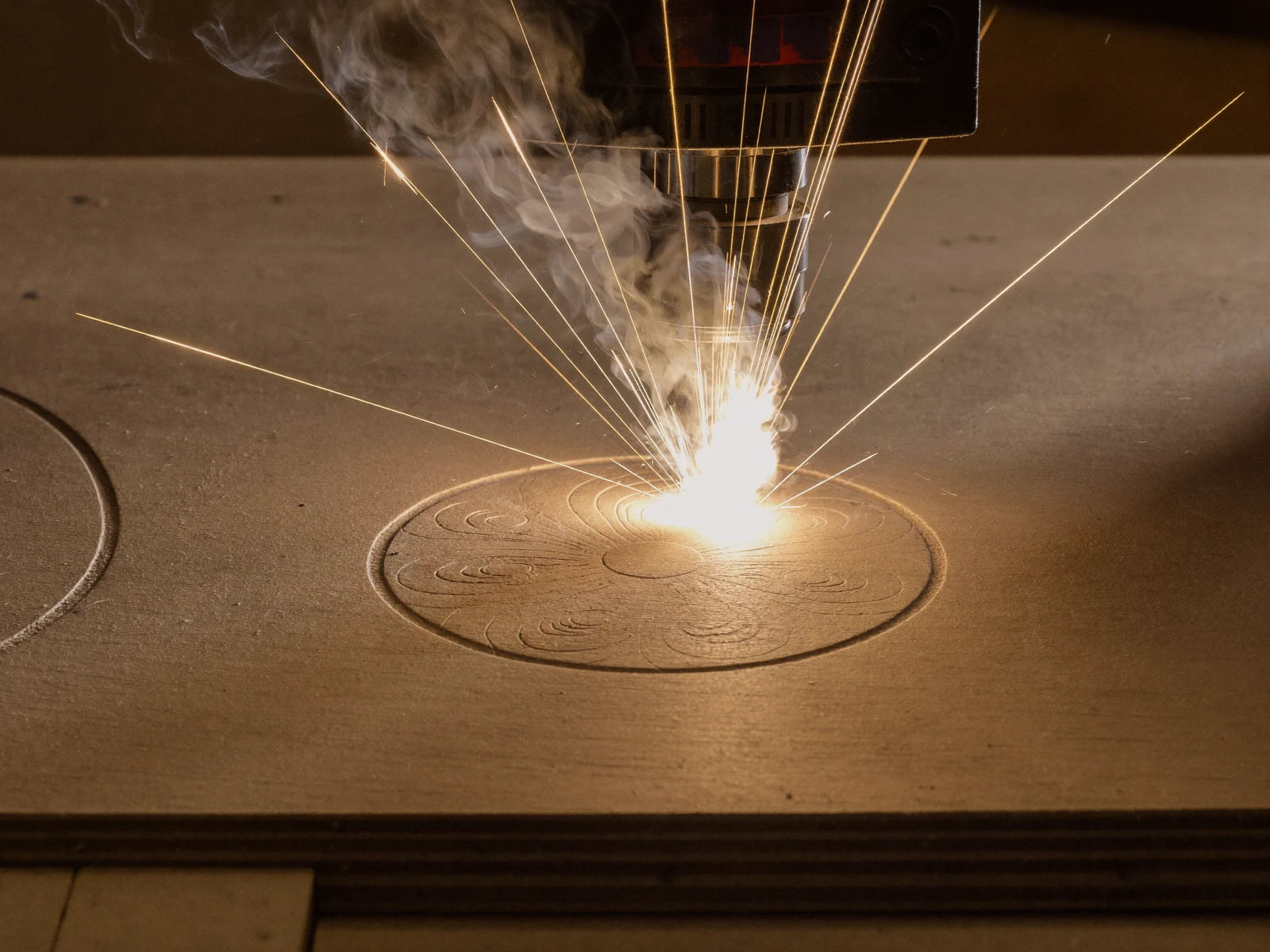 A laser cutting an intricate pattern into plywood.